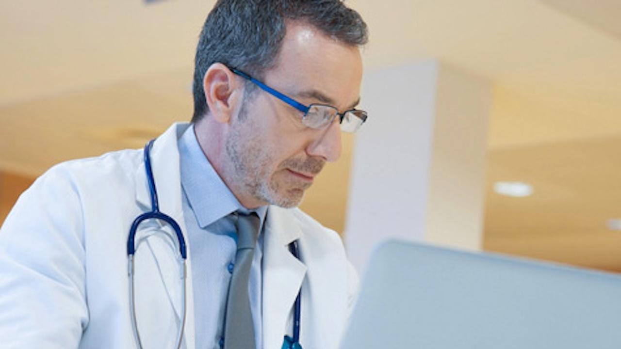 doctor in hospital office working on laptop