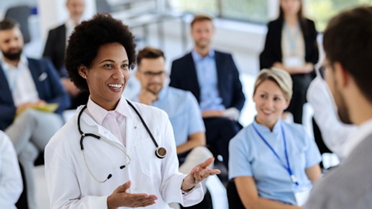 happy female doctor talking to businessman holding seminar