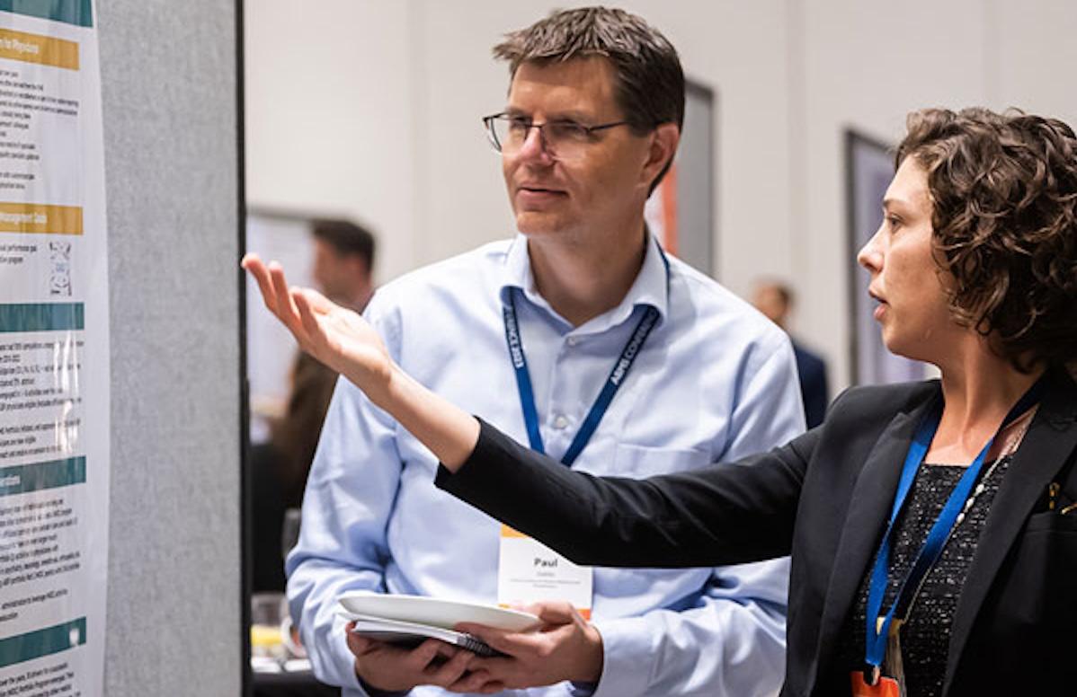 a man and woman looking at a research program presentation