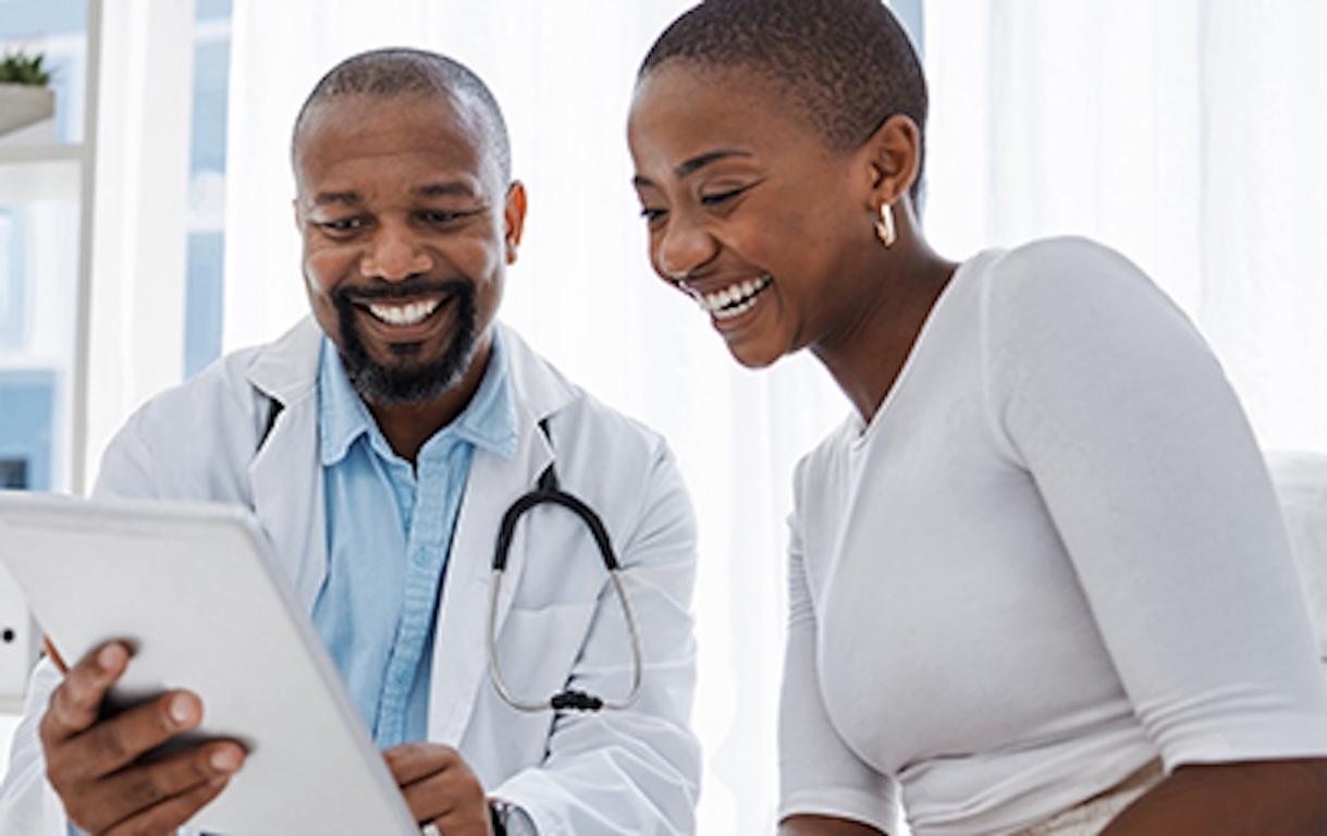 black doctor with black patient talking test results on tablet