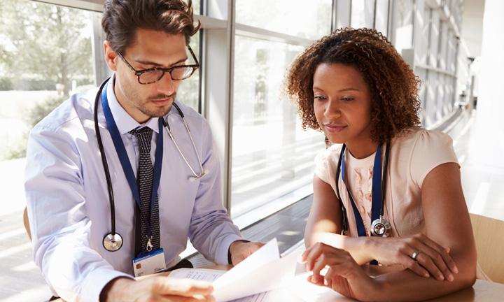 male doctor speaks with female doctor
